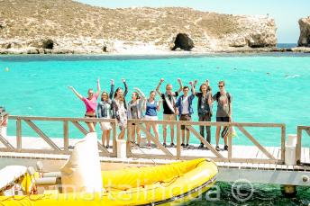 Un grupo de estudiantes cerca del barco en Blue Lagoon, Comino