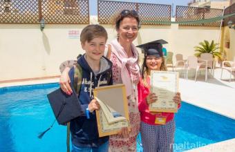 Una madre con sus dos hijos habiendo completado el curso de lengua inglesa