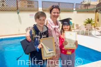 Una madre con sus dos hijos habiendo completado el curso de lengua inglesa