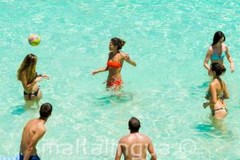 Jóvenes estudiantes jugando al volleyball en Blue Lagoon, Malta