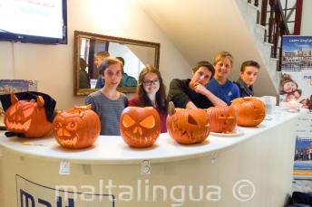 Jóvenes estudiantes con calabazas talladas en la recepción