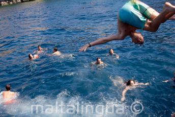 Un joven estudiante dando un salto al mar