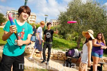 Estudiantes juegan al baseball y al frisbee en el parque de la residencia