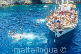 Estudiantes de inglés saltando del barco en Crystal Bay, Comino.