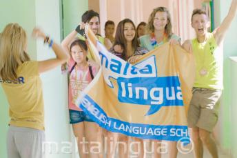 Un grupo de estudiantes sujetando una bandera en la escuela de verano