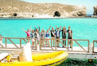 Un grupo de estudiantes cerca del barco en Blue Lagoon, Comino