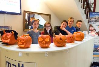 Jóvenes estudiantes con calabazas talladas en la recepción