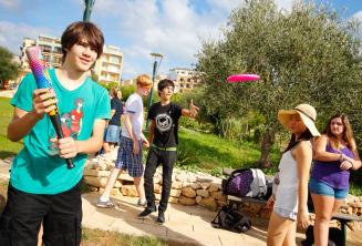 Estudiantes juegan al baseball y al frisbee en el parque de la residencia