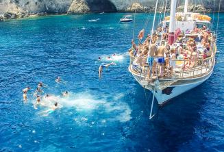 Estudiantes de inglés saltando del barco en Crystal Bay, Comino.