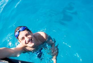 Un estudiante nadando cerca del barco en Comino.