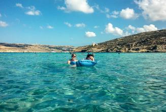 Estudiantes de la escuela de inglés nadando en la Laguna Azul en Comino