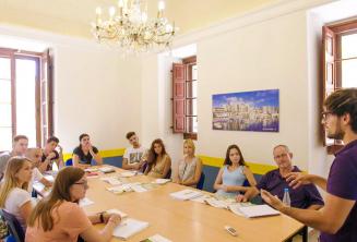 Estudiantes escuchando al profesor en clase de lengua inglesa